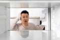 Shocked chinese man looking inside empty fridge Royalty Free Stock Photo
