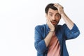 Shocked concerned young man stare speechless and distressed camera, grab head with both hands and gasping, look worried Royalty Free Stock Photo