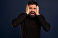 Shocked concerned young man stare speechless and distressed at camera, grab head with both hands and gasping, look worried and Royalty Free Stock Photo