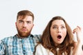 Shocked couple looking TV at home