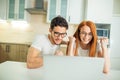 Shocked couple watching something on laptop at home