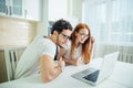 Shocked couple watching something on laptop at home