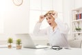 Shocked doctor with glasses sitting at the desktop Royalty Free Stock Photo