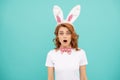 shocked easter woman with bunny ears on blue background