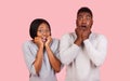 Shocked emotional african american couple over pink background
