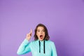 Shocked emotional young woman posing isolated over purple background wall