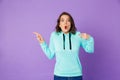 Shocked emotional young woman posing isolated over purple background wall