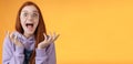 Shocked excited overwhelmed young screaming happy redhead girl wearing glasses winning hear excellent news yelling out Royalty Free Stock Photo