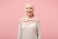 Shocked excited young arabian muslim woman in hijab light clothes posing isolated on pink background studio portrait Royalty Free Stock Photo