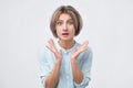 Shocked excited young lady standing isolated over white background.