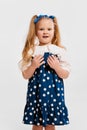 Shocked face. Beautiful cute little girl, child in retro style dress posing against grey studio background. Concept of Royalty Free Stock Photo