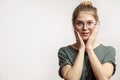 Shocked female with bugged eyes looking at camera, hands holds near cheeks Royalty Free Stock Photo