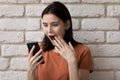 Shocked female teenager looking on phone screen reading stunning news Royalty Free Stock Photo