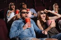 Shocked friends sitting in cinema watch film