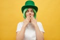 Shocked frighten woman with green hair wearing leprechaun hat posing isolated over yellow background looking at scared eyes sees Royalty Free Stock Photo