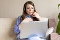 Shocked frightened afraid worried young woman in headphones looking at laptop Royalty Free Stock Photo