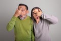 Shocked frightened old european man and woman with open mouth covers eyes with hands Royalty Free Stock Photo