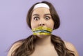 Shocked frightened pretty hungry caucasian plus size young woman with closed mouth with measuring tape