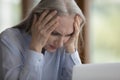 Shocked frustrated mature elderly woman touching head at laptop Royalty Free Stock Photo