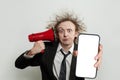 Shocked frustrated stressed businessman holding red loudspeaker and smartphone with blank empty white screen display on white