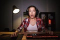 Shocked girl gamer sitting at the table Royalty Free Stock Photo