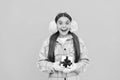 shocked happy kid in winter earmuffs with box. teen girl in mittens hold present