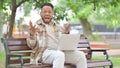 Shocked Hispanic Man in Park with Laptop Looking at Camera Royalty Free Stock Photo