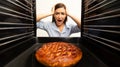 Shocked housewife checking her oven, looking at burnt pie Royalty Free Stock Photo