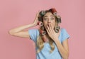 Shocked housewife in curlers covers her mouth with hand Royalty Free Stock Photo