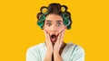 Shocked Housewife With Opened Mouth Looking At Camera, Yellow Background