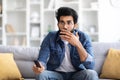 Shocked Indian Man With Remote Controller In Hand Sitting On Couch Royalty Free Stock Photo