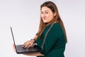 Shocked but interested caucasian obese woman with laptop, looking wit interest at camera. Businesswoman, working distant