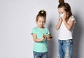 Shocked kid girl in medical mask protecting herself from corona in sisters hands during coronavirus epidemic