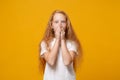 Shocked little ginger kid girl 12-13 years old in white t-shirt isolated on yellow wall background children studio Royalty Free Stock Photo