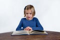 Shocked little girl with a book on a white background