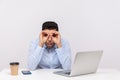 Shocked man employee sitting office workplace with laptop on desk, looking through binoculars hand gesture