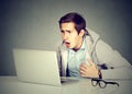 Shocked man with laptop computer sitting at table Royalty Free Stock Photo