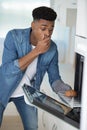 shocked man looking at burnt cookies in oven Royalty Free Stock Photo