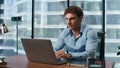 Shocked man reading bad news office. Big eyes businessman looking laptop screen