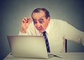 Shocked man reading message on computer in office Royalty Free Stock Photo