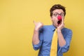 Shocked man with red clown nose looking camera showing pointing on copyspace. Clown, corcus or show concept.