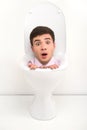 Shocked man sitting inside toilet seat. Royalty Free Stock Photo