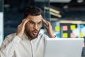 A man with a look of shock touches his head while looking at his laptop screen. Royalty Free Stock Photo