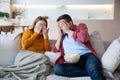 Scared family couple cover eyes with palms watching horrifying movie series sitting on couch at home Royalty Free Stock Photo