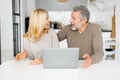 Shocked middle-aged couple feel euphoric sitting at the desk in front of laptop Royalty Free Stock Photo