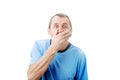 Shocked middle aged man with wide opened eyes covering his mouth with his hand isolated on white background with copy space. Royalty Free Stock Photo