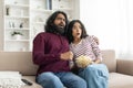 Shocked millennial indian couple watching horror movie on TV Royalty Free Stock Photo