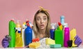 Shocked millennial woman holds hands cleaning supplies