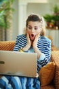 Shocked modern female with laptop in modern house in sunny day Royalty Free Stock Photo