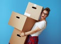 Shocked modern woman holding pile of cardboard boxes on blue Royalty Free Stock Photo